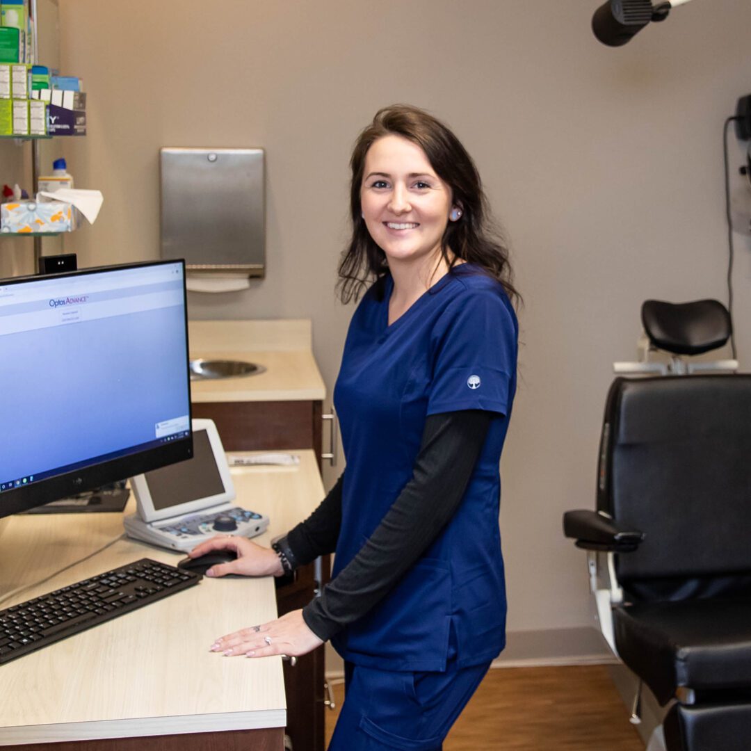 A woman standing in front of a computer.